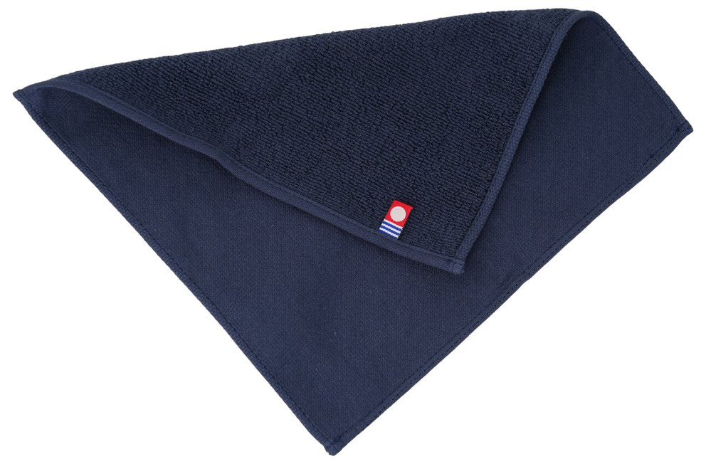 ネイビーのハンカチの接写。パイル面とガーゼ面が重なり、角に今治タオルのブランドタグが縫い付けられている